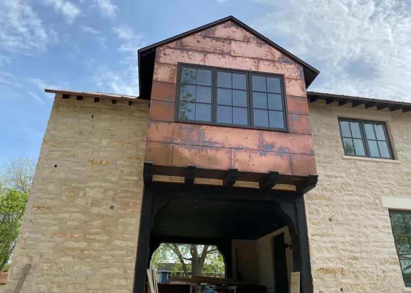Copper metal panel facade on a stone building for Skylight Installation in Itasca