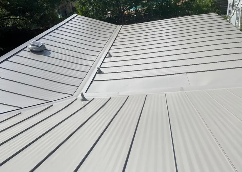Solar attic fan installed on a metal roof for Roof Ventilation in Itasca